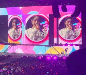 Image of k-pop idol Dahyun singing on multiple large concert monitors.